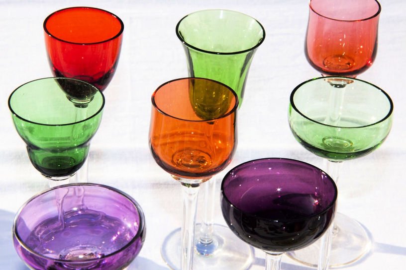 mixed brightly coloured drinks glasses in a charity shop bric a brac section